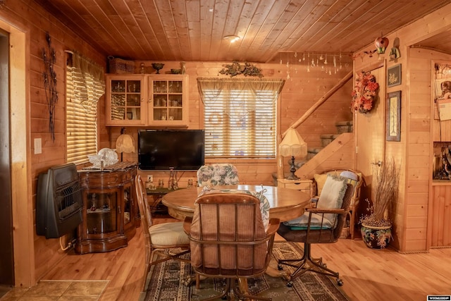 sitting room with wood walls, wooden ceiling, heating unit, and wood-type flooring