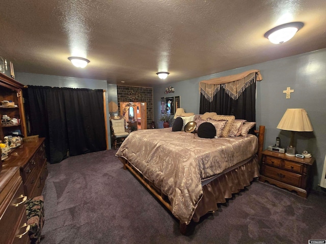 bedroom with dark carpet and a textured ceiling