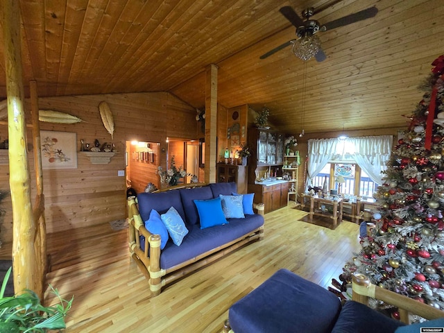 living room featuring wood ceiling, light hardwood / wood-style floors, ceiling fan, lofted ceiling, and wooden walls