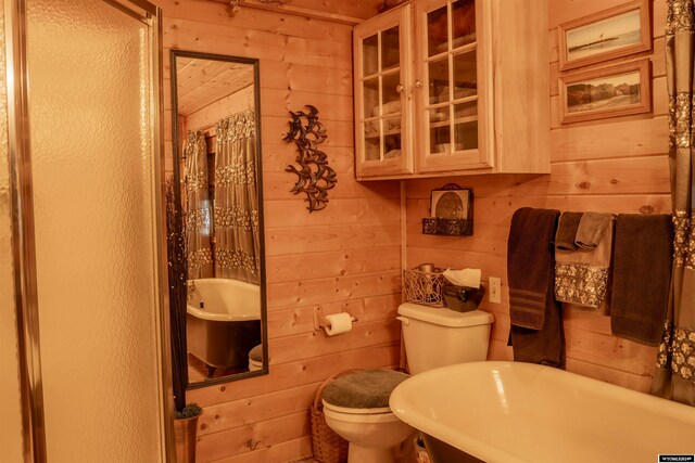 bathroom featuring toilet and wooden walls