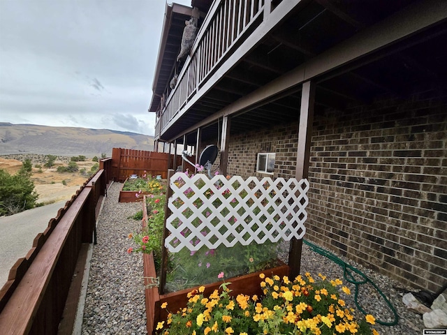 43 Red Cliff Dr, Lander, WY 82520 - view of side of home with brick siding, fence, and a mountain view
