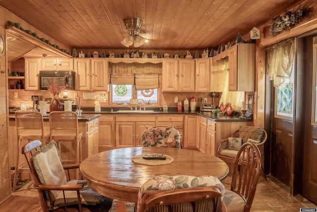43 Red Cliff Dr, Lander, WY 82520 - kitchen with dark countertops, black microwave, a sink, light brown cabinets, and wood ceiling