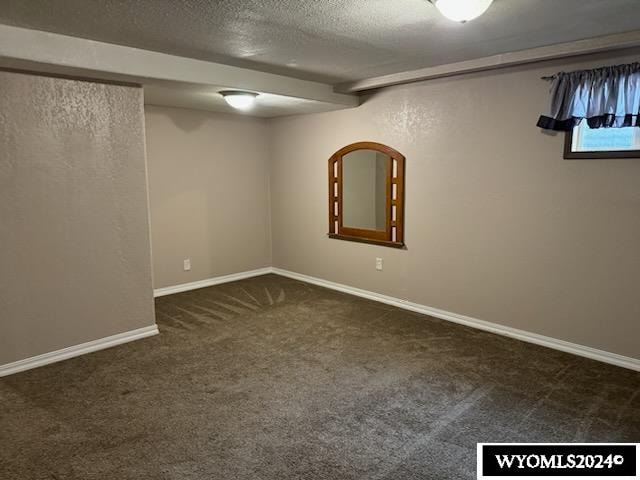 basement with a textured ceiling and dark carpet