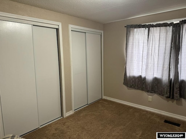 unfurnished bedroom with carpet and a textured ceiling