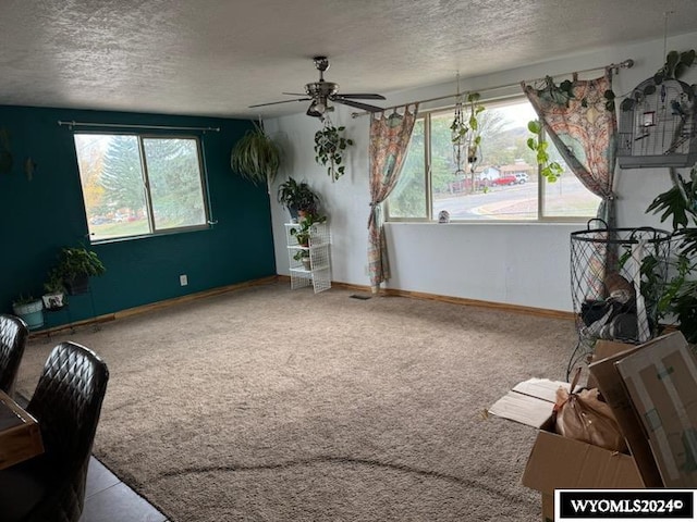 carpeted living room featuring a textured ceiling and ceiling fan