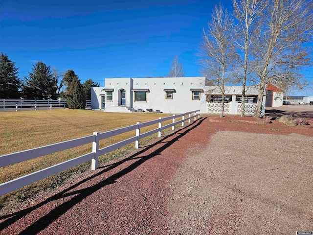 adobe home featuring a front lawn