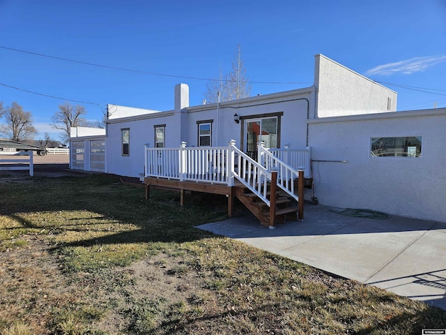 4380 US Highway 26-85, Torrington, WY 82240 - rear view of property with a deck, stucco siding, a patio, and a lawn