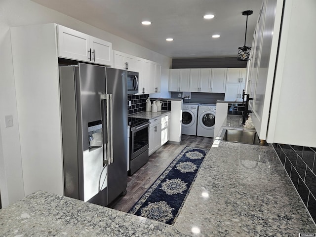 4380 US Highway 26-85, Torrington, WY 82240 - kitchen featuring appliances with stainless steel finishes, independent washer and dryer, white cabinets, dark wood-type flooring, and a sink