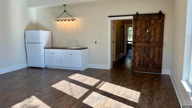 58 Bethel Rd, Buffalo, WY 82834 - kitchen featuring sink, a barn door, pendant lighting, white fridge, and dark wood-type flooring