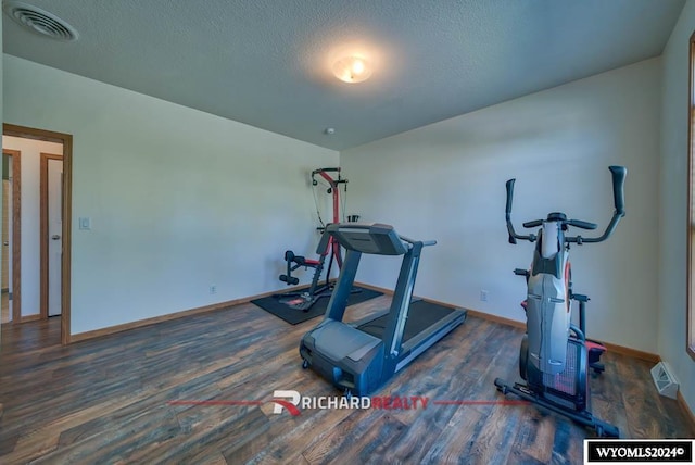 1559 Rd 13, Worland, WY 82401 - workout room featuring wood finished floors, baseboards, and a textured ceiling