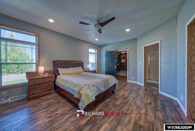 1559 Rd 13, Worland, WY 82401 - bedroom featuring wood finished floors, baseboards, a barn door, recessed lighting, and a walk in closet