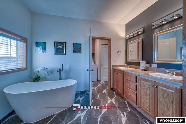1559 Rd 13, Worland, WY 82401 - bathroom featuring double vanity, marble finish floors, and a freestanding tub