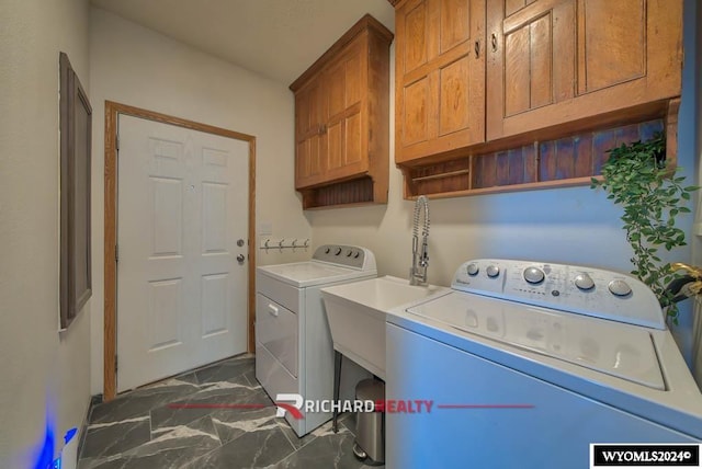 1559 Rd 13, Worland, WY 82401 - laundry area featuring separate washer and dryer, cabinet space, and dark marble finish floors