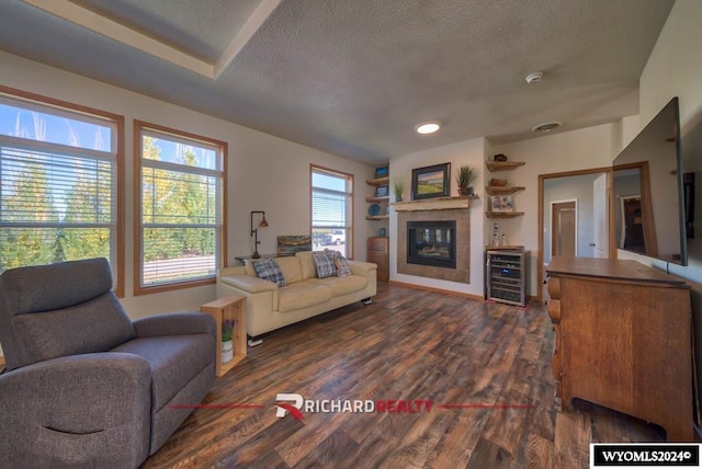 1559 Rd 13, Worland, WY 82401 - living room with a fireplace, a textured ceiling, wine cooler, dark wood-style flooring, and recessed lighting