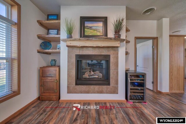 1559 Rd 13, Worland, WY 82401 - living area featuring wine cooler, wood finished floors, baseboards, and a tile fireplace