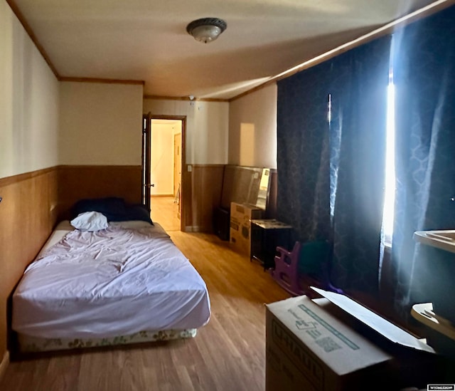 bedroom featuring ornamental molding and light wood-type flooring