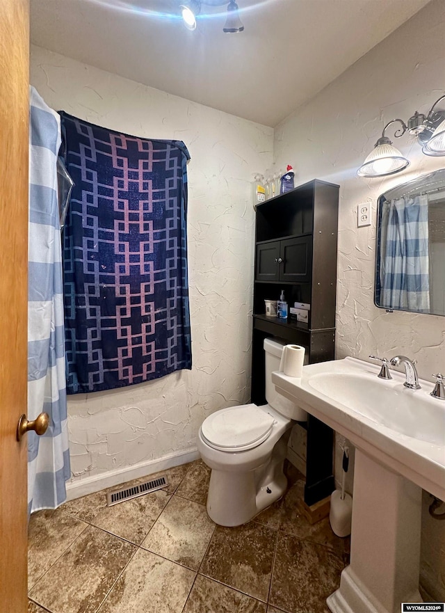 bathroom with toilet, a shower with curtain, and tile patterned floors