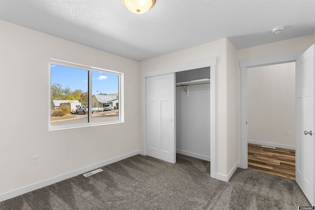 unfurnished bedroom with a closet, a textured ceiling, and carpet flooring