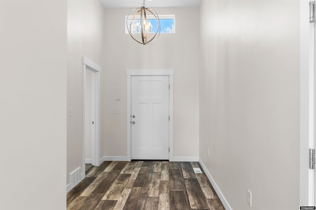 entryway with a notable chandelier and dark wood-type flooring