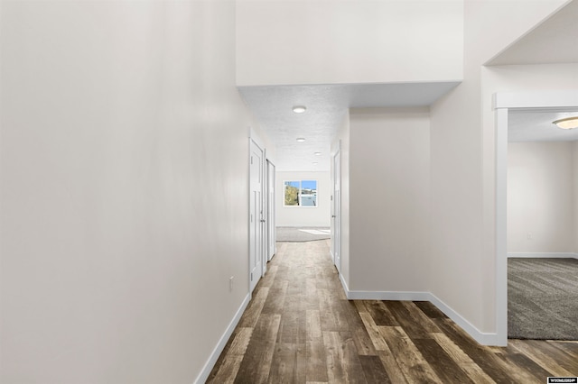 corridor with dark hardwood / wood-style flooring