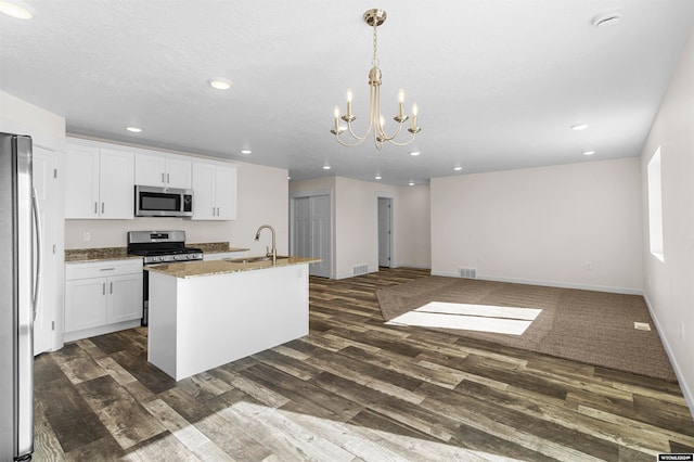 kitchen with appliances with stainless steel finishes, white cabinets, a kitchen island with sink, and dark hardwood / wood-style flooring