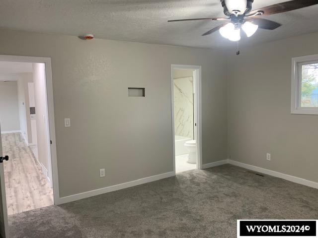 unfurnished room with ceiling fan, carpet floors, and a textured ceiling