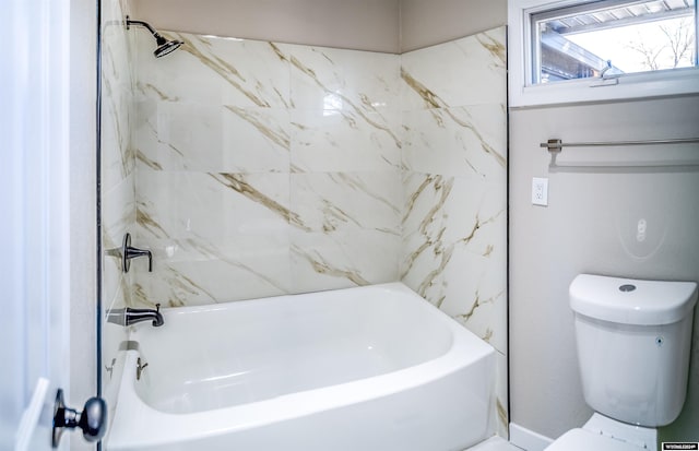 bathroom with toilet and tiled shower / bath