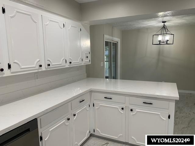 kitchen featuring white cabinets, decorative light fixtures, and kitchen peninsula