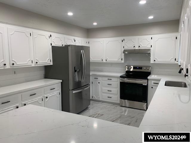 kitchen featuring backsplash, sink, white cabinetry, and stainless steel appliances