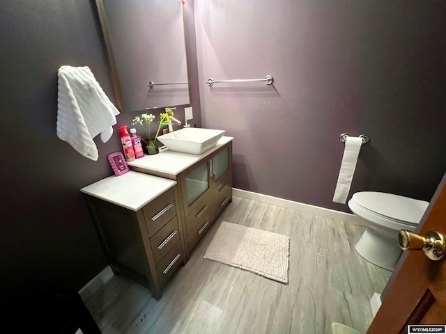 bathroom with vanity, toilet, and wood-type flooring