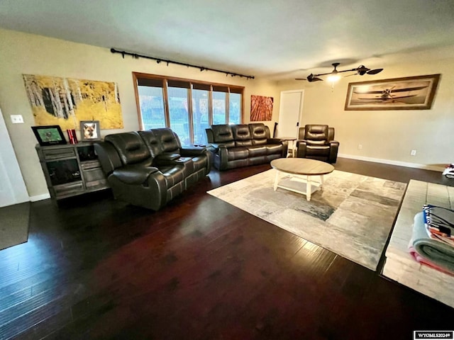 living room featuring ceiling fan and dark hardwood / wood-style flooring