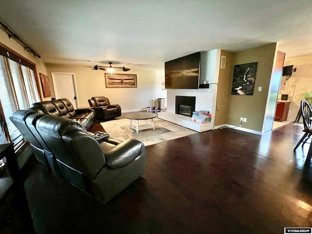 living room with wood-type flooring and a brick fireplace