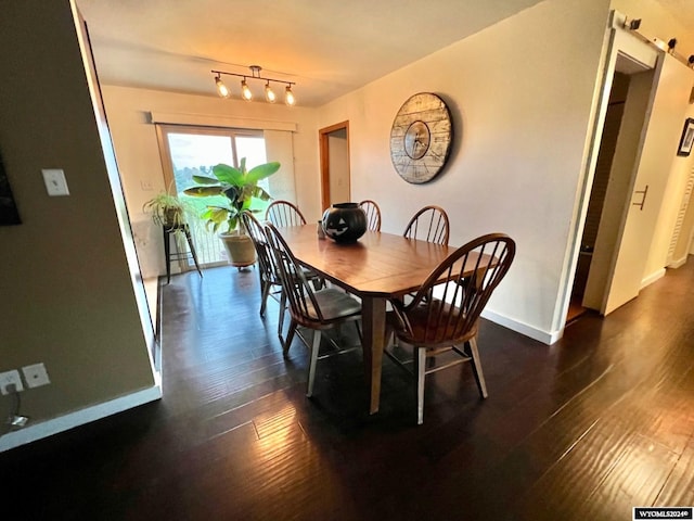 dining room featuring dark hardwood / wood-style floors and a barn door