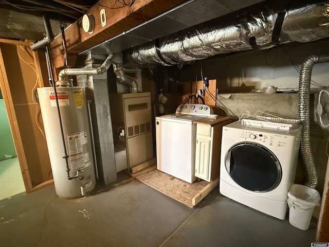 laundry room with cabinets, washing machine and dryer, and gas water heater