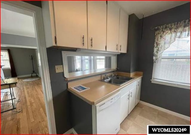 kitchen with white cabinetry, dishwasher, light wood-type flooring, and sink