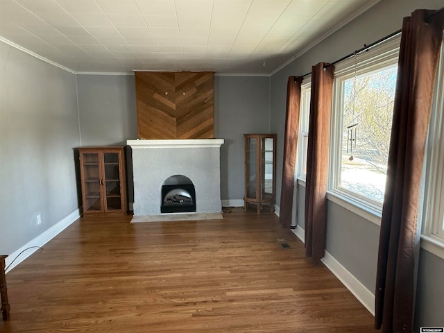 unfurnished living room featuring ornamental molding and hardwood / wood-style flooring