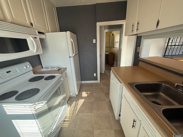 kitchen with white appliances, light tile patterned floors, and sink