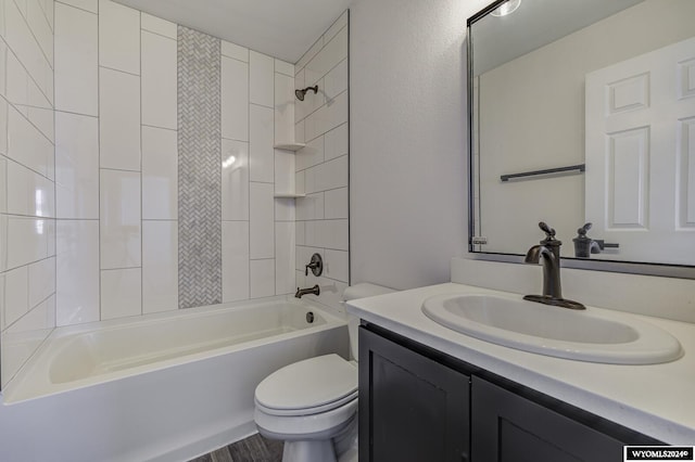 full bathroom with vanity, tiled shower / bath combo, and toilet