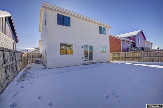 snow covered rear of property with cooling unit and a patio area