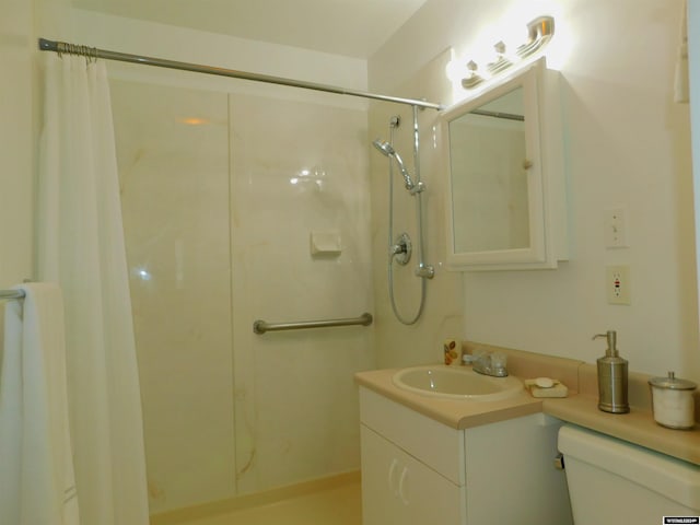 bathroom with toilet, vanity, and a shower with shower curtain