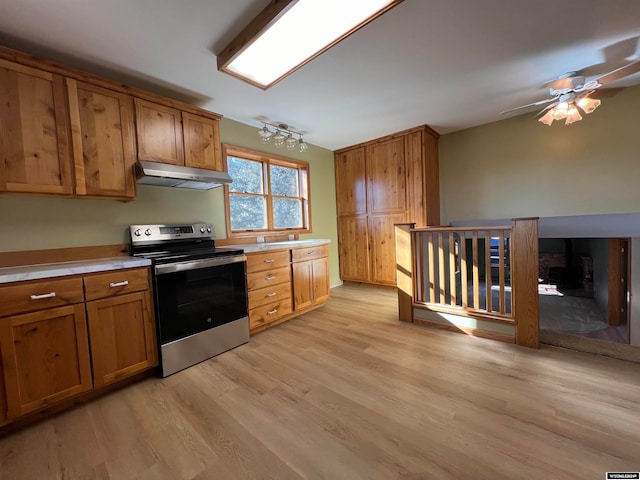 kitchen featuring stainless steel range with electric cooktop, ceiling fan, and light hardwood / wood-style flooring