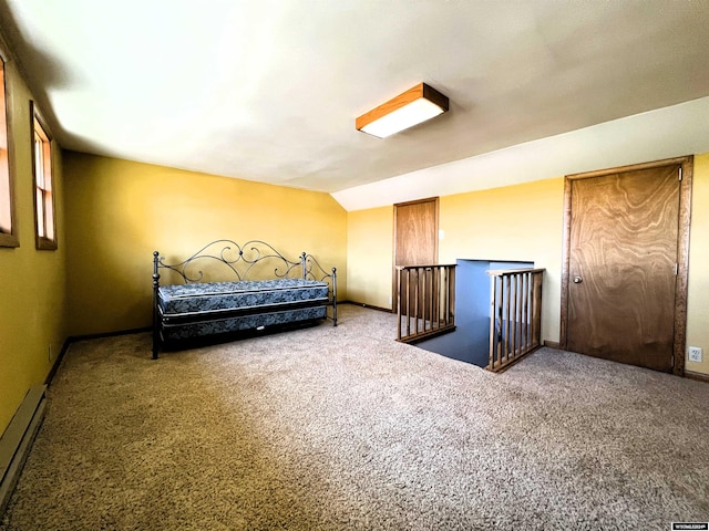 carpeted bedroom featuring a baseboard heating unit and lofted ceiling