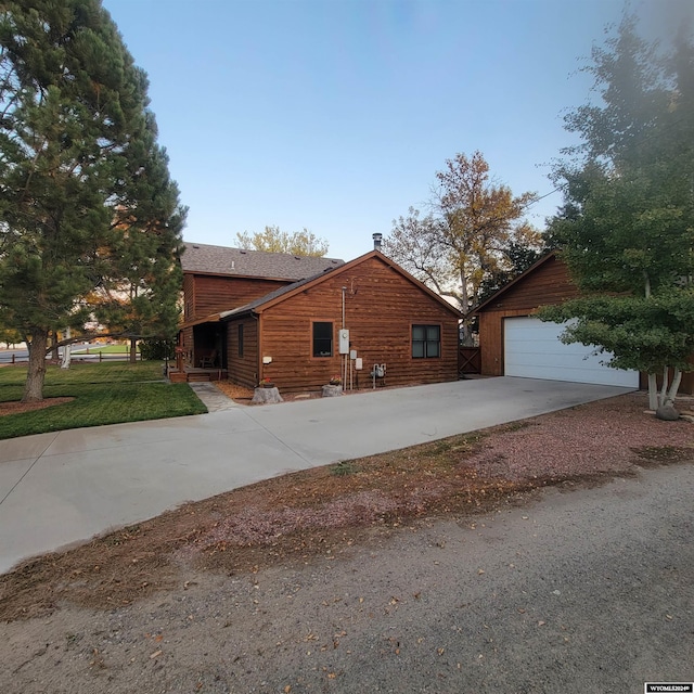 view of side of home featuring a garage, an outdoor structure, and a yard