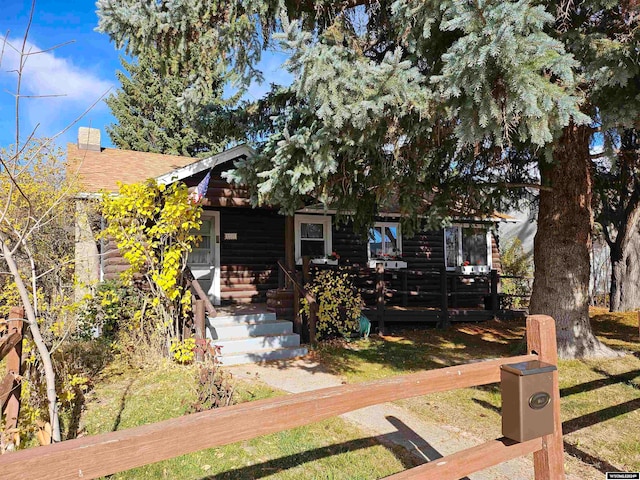 view of property hidden behind natural elements featuring a front lawn