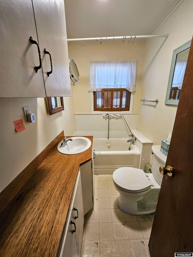 bathroom with vanity, toilet, a tub, and crown molding