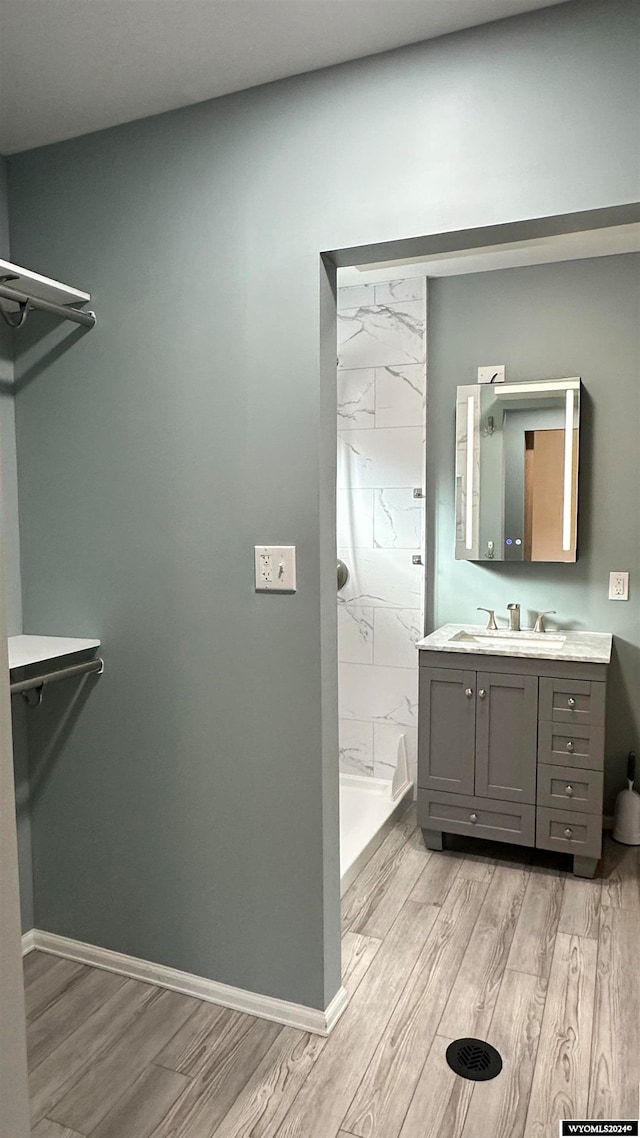 bathroom with walk in shower, hardwood / wood-style floors, and vanity