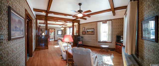 living room featuring light wood-type flooring, coffered ceiling, ceiling fan, and beam ceiling