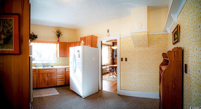 kitchen featuring decorative backsplash, white fridge with ice dispenser, and sink