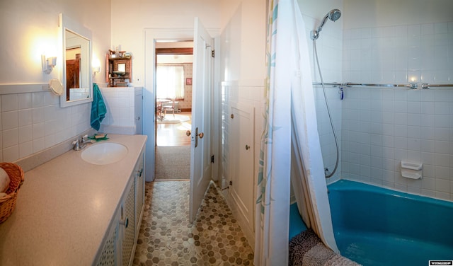 bathroom featuring vanity, tile patterned floors, shower / bathtub combination with curtain, and tile walls