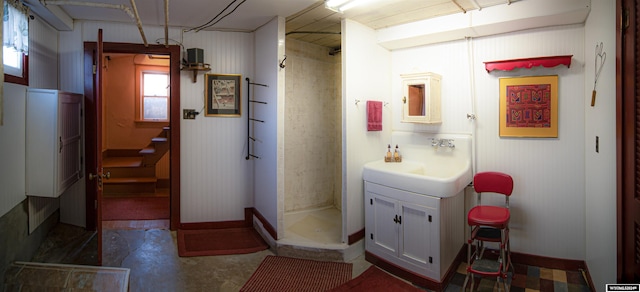 bathroom featuring walk in shower, vanity, and concrete floors